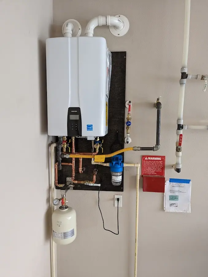 Professional plumber installing copper piping in a Stonegate home